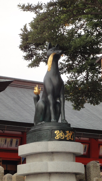 a dark fox statue with gold accents